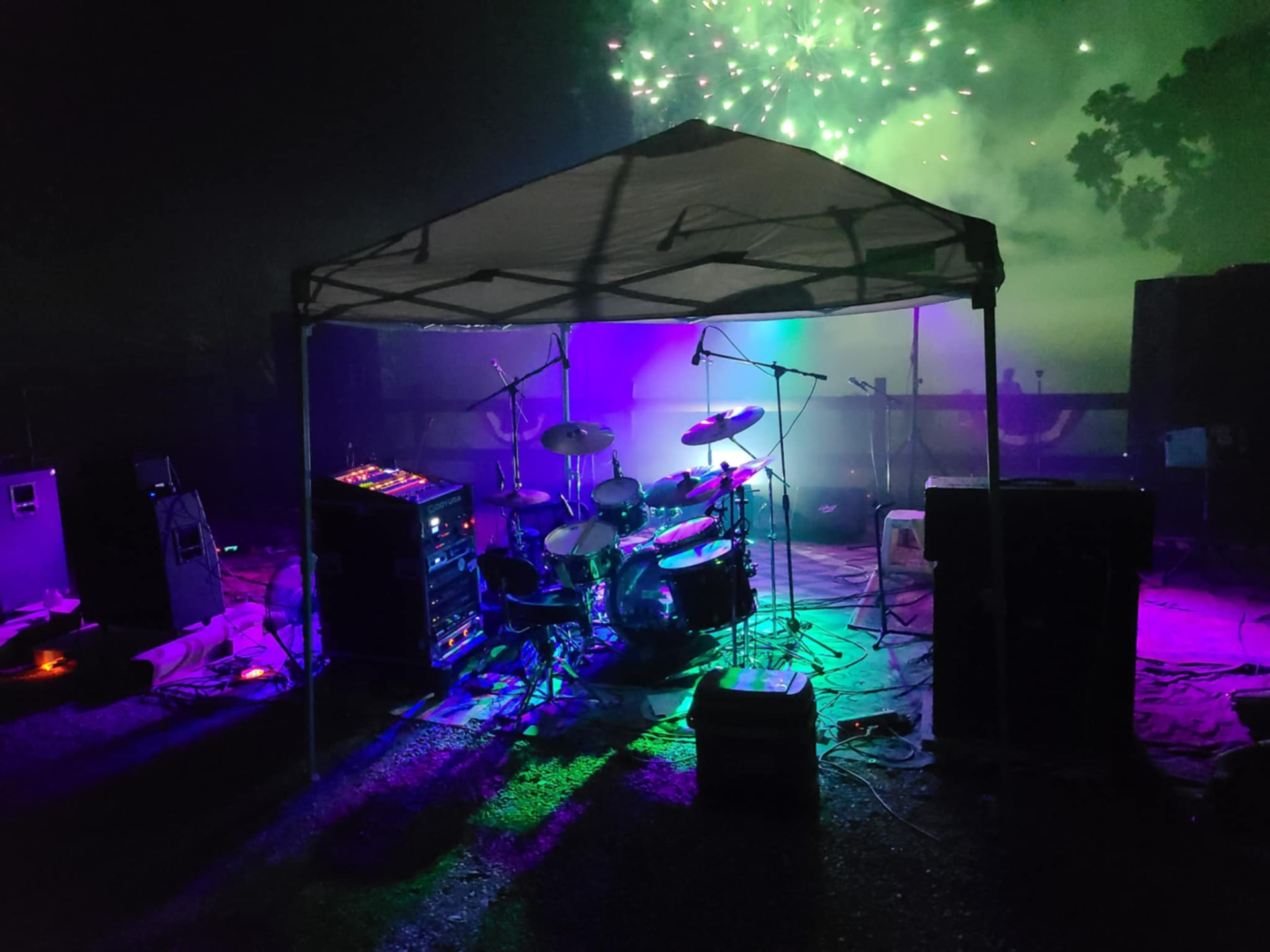 Drum kit under stage lights with fireworks overhead