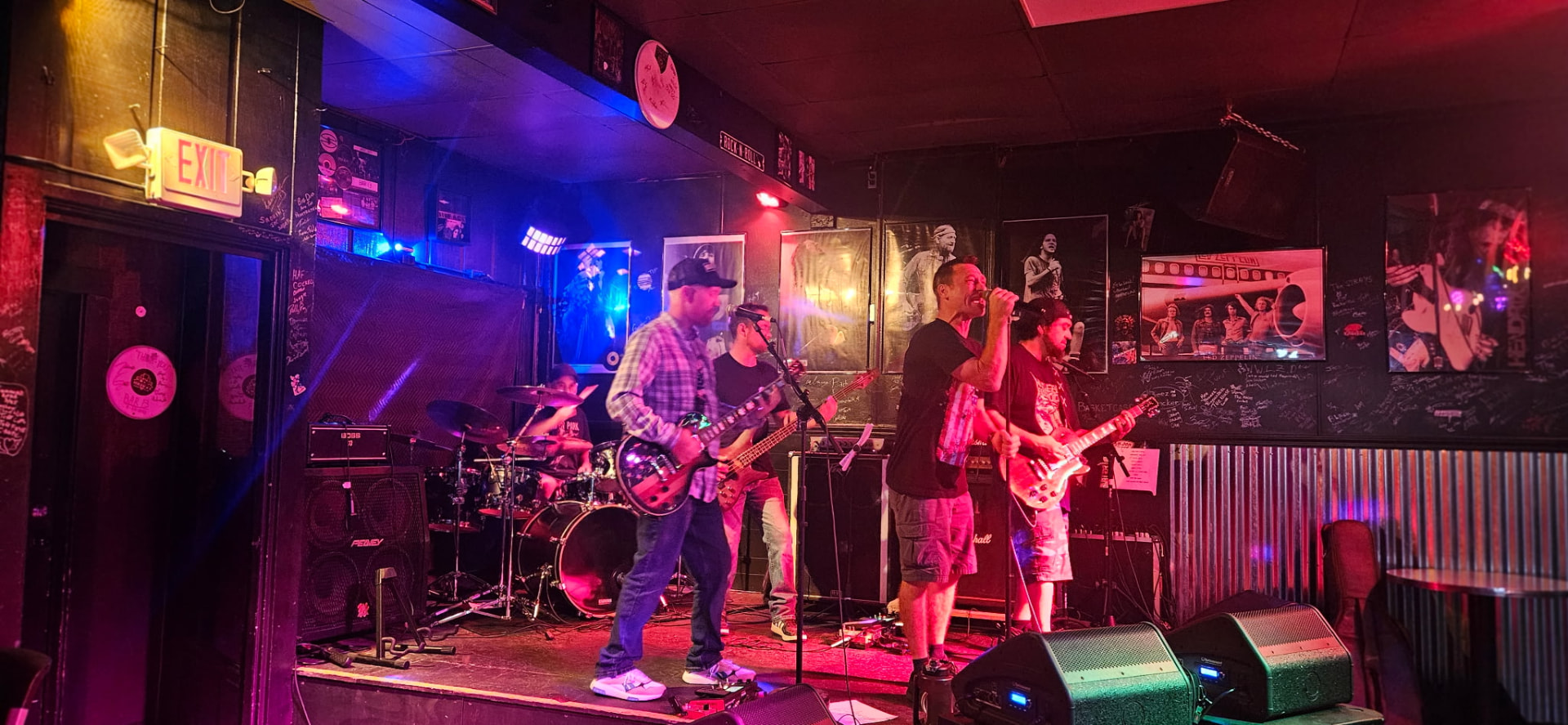 Piece of Me mid-set on a bar stage under red and blue light